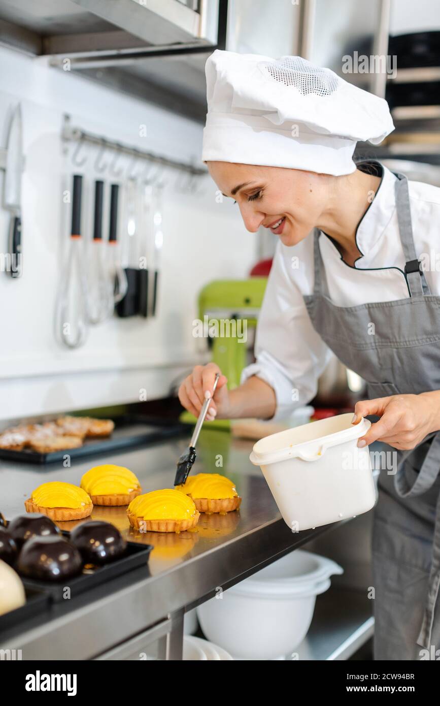 Confiseur travaillant sur petits gâteaux sucrés Banque D'Images