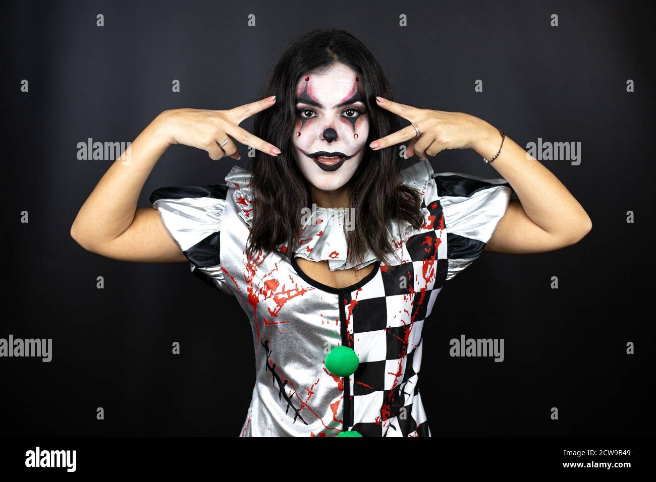 Femme dans un costume de clown d'halloween sur fond noir isolé faisant  symbole de paix avec les doigts sur le visage, souriant gai montrant la  victoire Photo Stock - Alamy