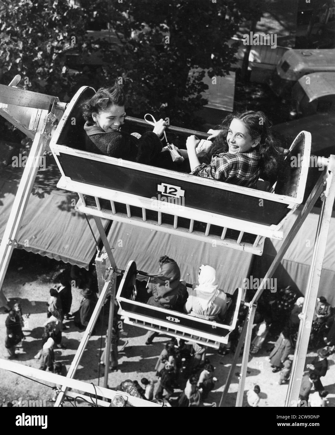 Les jeunes filles souriantes regardent le photographe à bord de la grande roue d'une foire du comté, Lancaster, Ohio, 1949. (Photo de l'Agence d'information des États-Unis/RBM Vintage Images) Banque D'Images