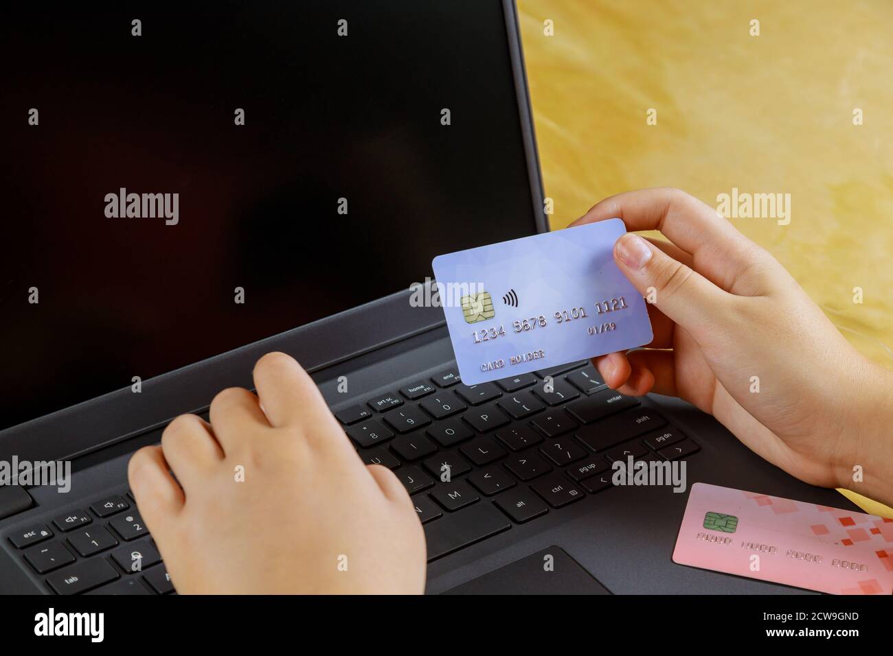 Travail sur ordinateur portable le vendredi noir du paiement en ligne de main tenant une carte de crédit Banque D'Images