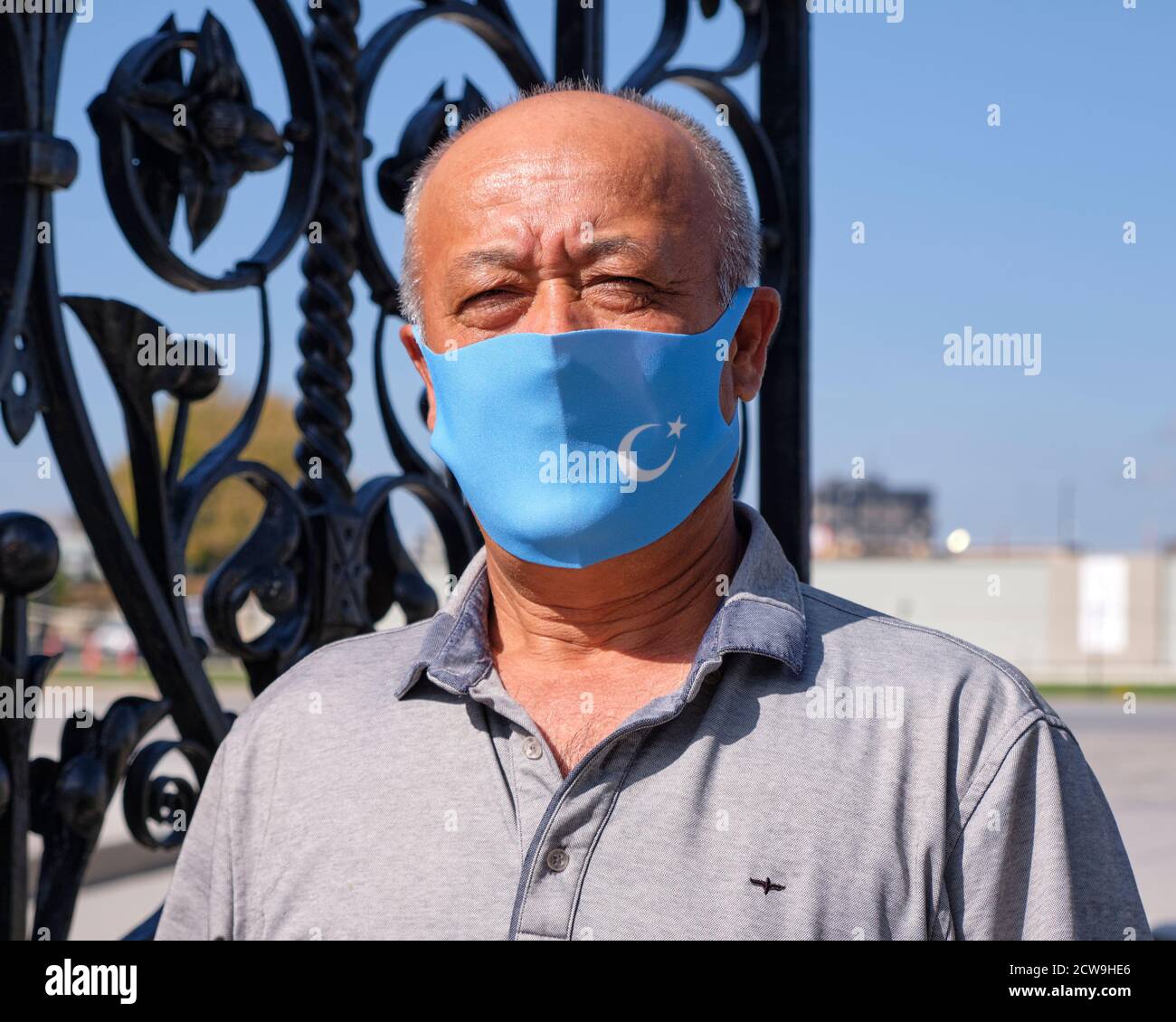 Le manifestant Uyghur portant un masque représentant le drapeau d'Uyghuristan fourni par l'organisateur en raison d'une pandémie Banque D'Images