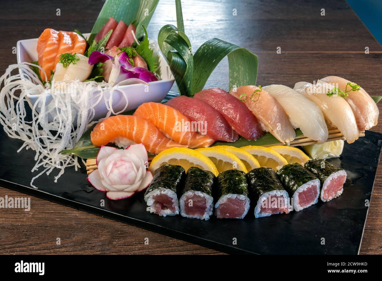 Assortiment de saladiers de sashimi de poisson cru avec plein de sushis et de rouleau de Californie à choisir comme un repas copieux. Banque D'Images