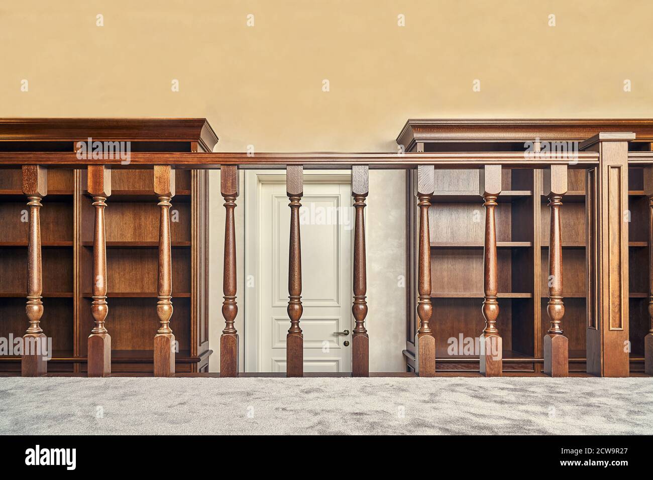 Bibliothèque personnelle. Bibliothèque en bois avec des étagères vides et une balustrade en bois placée dans la maison bibliothèque dans la maison Banque D'Images