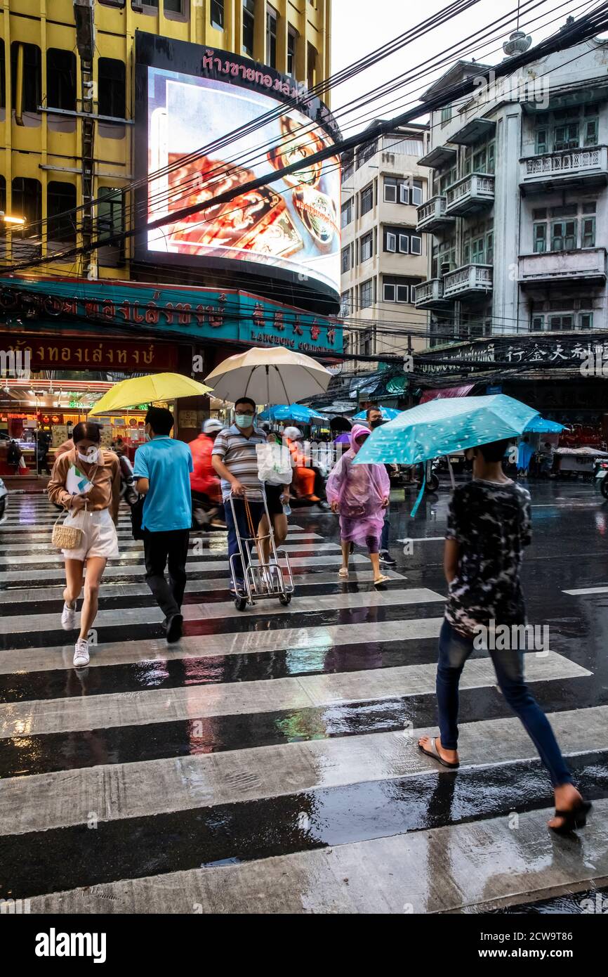 Les navetteurs se déplacent de l'autre côté de la rue pour commencer leur trajet pluvieux à la maison depuis le quartier chinois de Bangkok. Banque D'Images