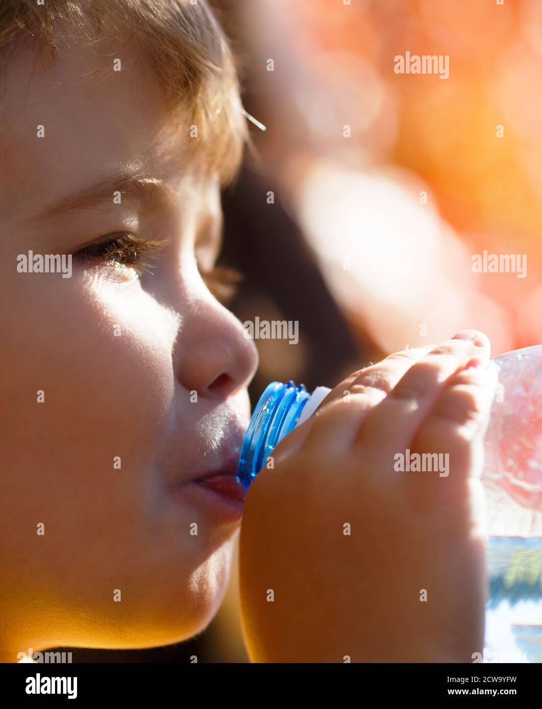 Bouteille d'eau pour garçon. Jeune garçon tenant boire bouteille d'eau douce Banque D'Images