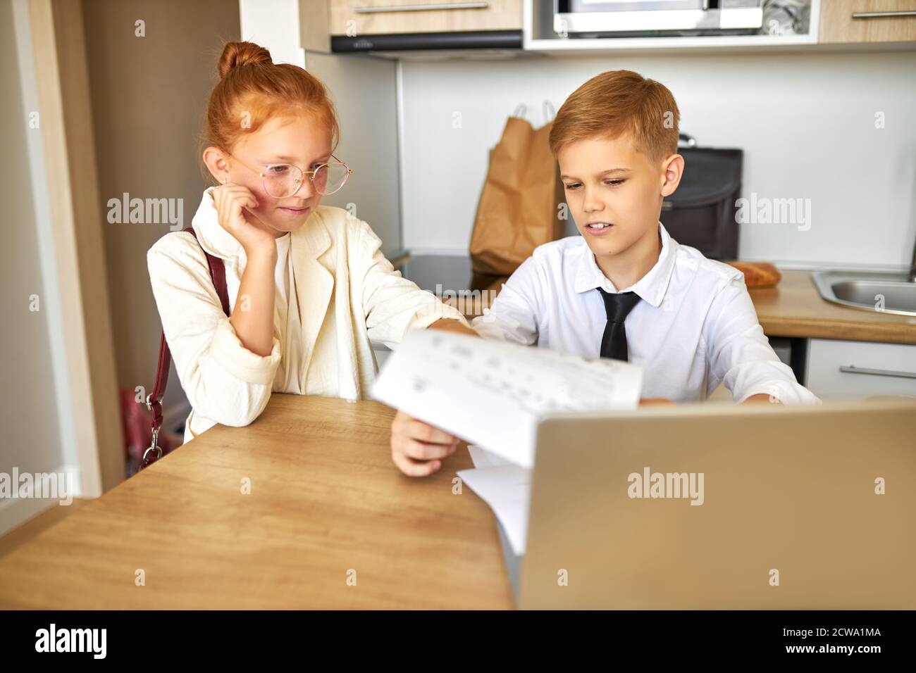 de beaux enfants de couples caucasiens travaillent ensemble sur un ordinateur portable, résolvent des problèmes de famille, paient des factures en ligne, parlent. à la maison, ils se comportent comme des adultes Banque D'Images