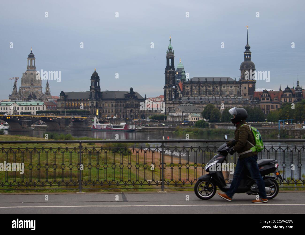 29 septembre 2020, Saxe, Dresde: Un homme pousse son scooter le matin au-dessus du pont de Marienbrücke lors d'une grève à jetons dans le service public. En arrière-plan, vous pourrez voir l'Elbe et la vieille ville avec la Frauenkirche (l-), le Ständehaus, la Hofkirche, l'hôtel de ville, le Kreuzkirche et le Semperoper. Dans le cadre des négociations collectives en cours, Verdi veut appliquer des réglementations uniformes pour la rémunération des heures supplémentaires, des indemnités de travail par quart, des congés autorisés et des paiements spéciaux pour environ 87,000 employés dans les transports publics locaux dans toute l'Allemagne. Photo: Robert Banque D'Images