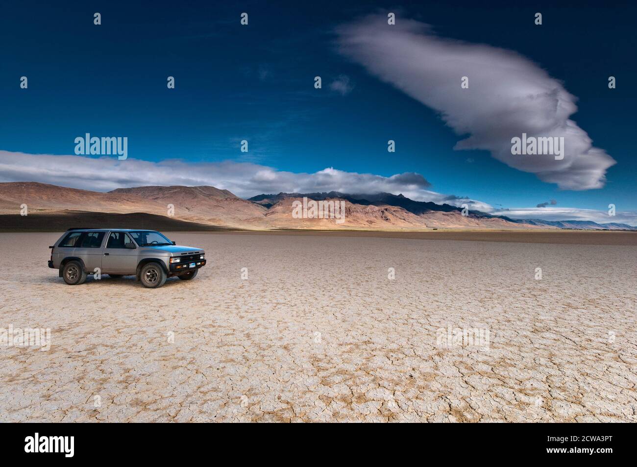 Voiture au lac sec Alvord. Steens Mountain in dist, cumulus Cloud, Alvord Desert, une partie du Grand bassin Desert, Oregon, États-Unis Banque D'Images