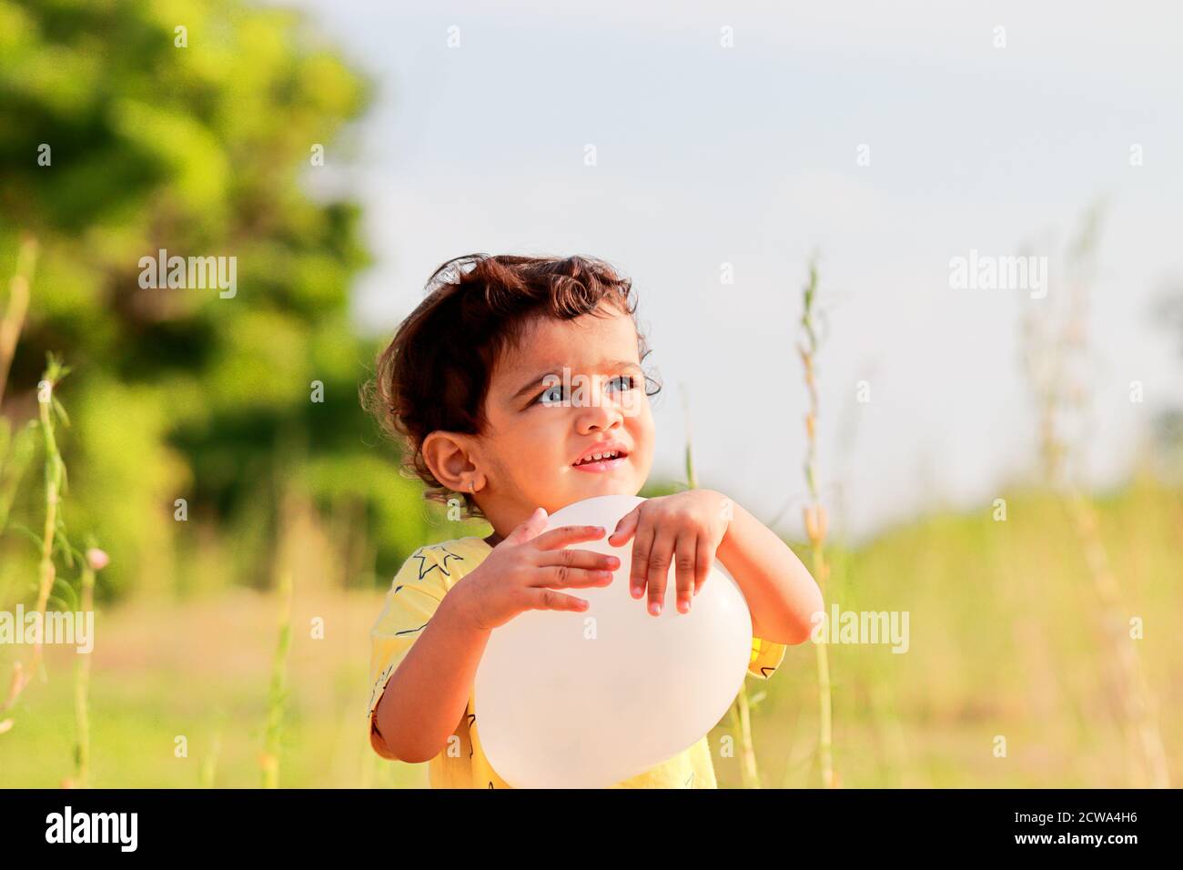 enfant asiatique jouant à l'extérieur avec le ballon Banque D'Images