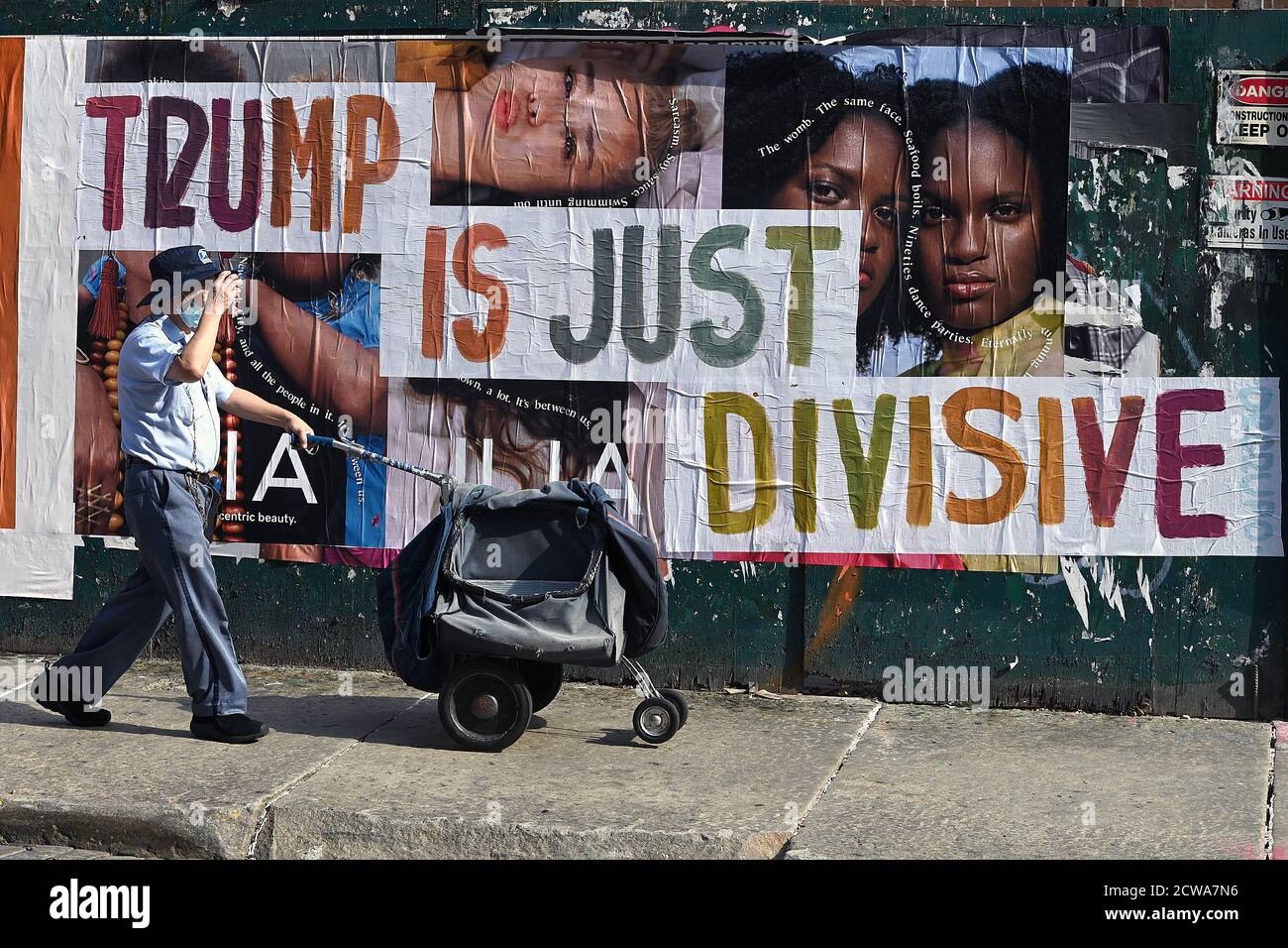 New York, États-Unis. 28 septembre 2020. Un employé de la poste des États-Unis pousse un panier de courrier au-delà d'une affiche avec une opinion politique reflétant les troubles raciaux et sociaux actuels aux États-Unis, New York, NY, le 28 septembre 2020. Un peu plus d’un mois avant les élections présidentielles américaines, les commentaires sous forme d’affiches, de panneaux et de dessins sont visibles à travers la ville, où New York est considérée comme un État « bleu » du Decocrat. (Anthony Behar/Sipa USA) crédit: SIPA USA/Alay Live News Banque D'Images