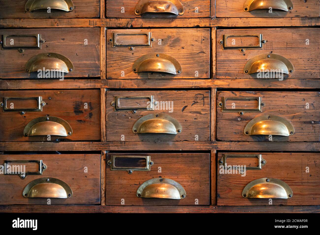 Une armoire de mobilier en bois de vieux tiroirs avec poignées en laiton Banque D'Images