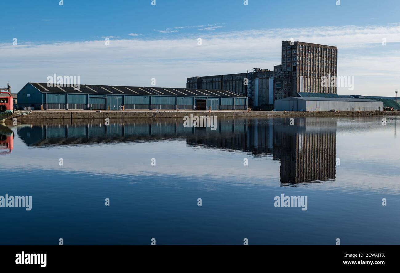 Météo: Soleil sur Leith. Le soleil brille vraiment sur l'eau de Leith et, lors d'une journée calme et ensoleillée, crée de merveilleuses réflexions dans l'eau autour des quais de Leith avec un grand silo de grain industriel et un entrepôt de stockage reflétés dans le port d'Imperial Dock Banque D'Images