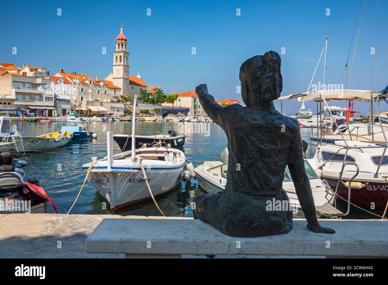 Vieille ville de Sutivan, statue de fille montrant la tour de l'église Banque D'Images