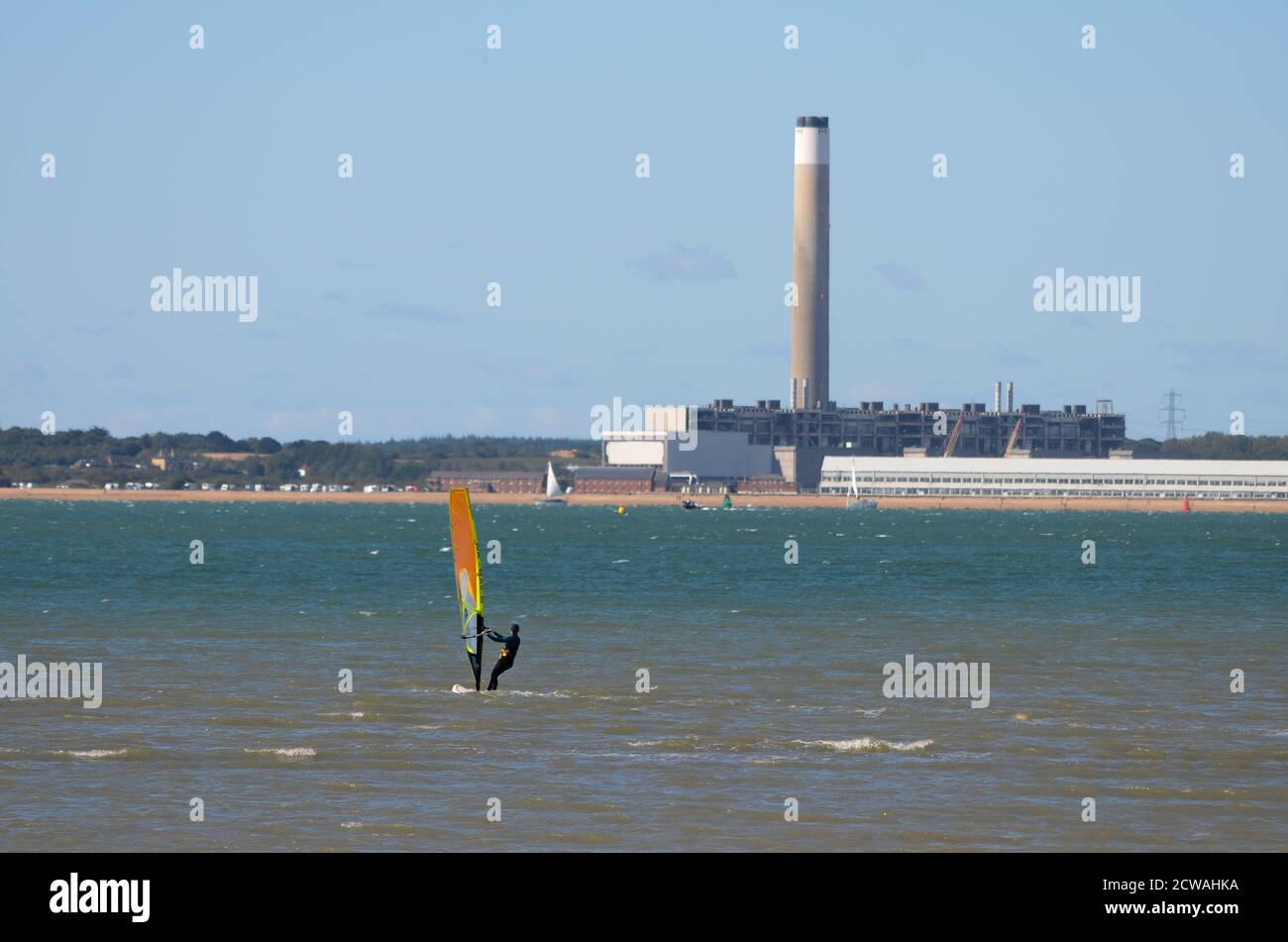 Planche à voile et centrale électrique de Fawley. La centrale électrique en arrière-plan est en cours de démontage, montrant la structure interne exposée. Banque D'Images