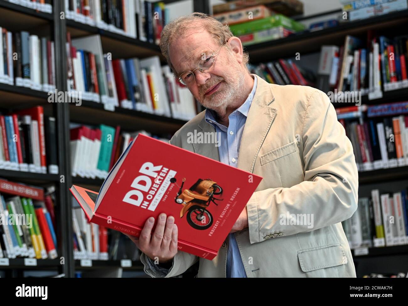 Berlin, Allemagne. 29 septembre 2020. Stefan Wolle, historien, tient dans sa main l'anthologie 'GDR in Objects 1949-1990: Loisir, Culture, Voyage'. La deuxième des trois anthologies sera publiée sur 01.10.2020 avec 4,000 exemplaires en édition limitée. Credit: Britta Pedersen/dpa-Zentralbild/dpa/Alay Live News Banque D'Images