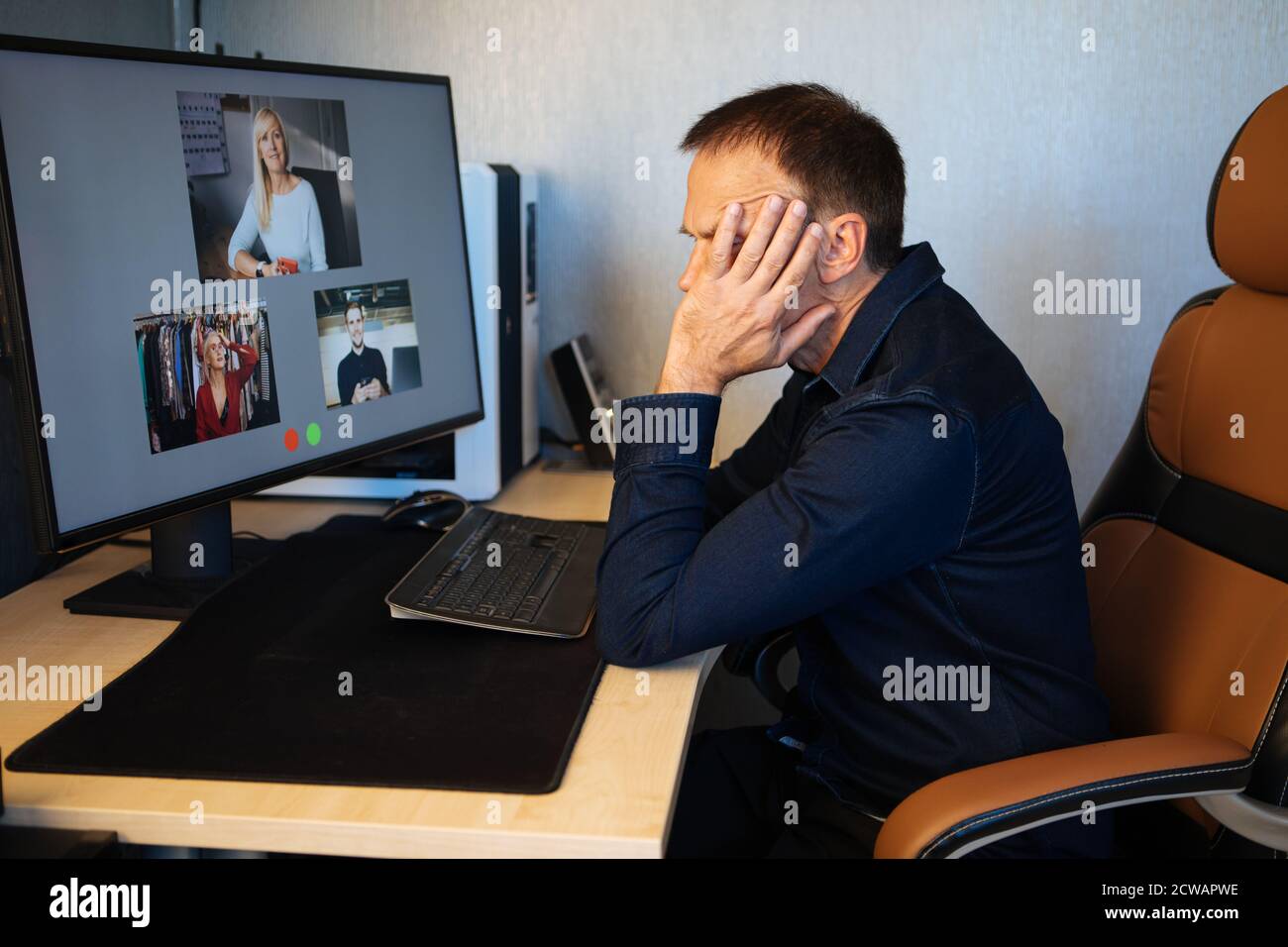 Homme d'affaires fatigué dormant sur son bureau tout en ayant un appel vidéo via un ordinateur dans le bureau à domicile. Réunion d'équipe à distance, vidéo, conférence en ligne Banque D'Images