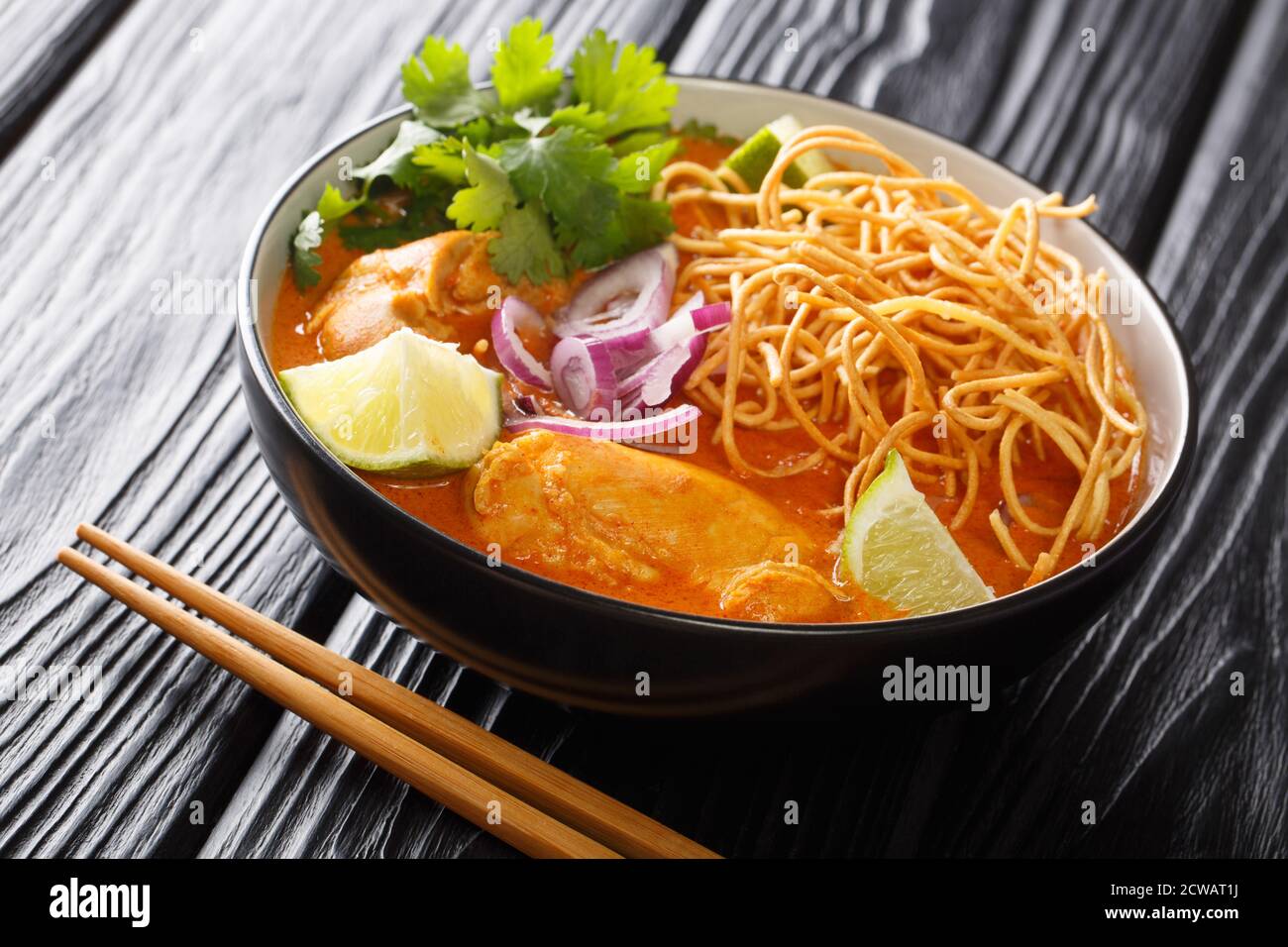 Tasty Khao soi, une soupe de nouilles originaire de Thaïlande, est chargé de poulet, échalotes, et l'ail dans un bouillon à base de lait de coco à proximité dans le bol le TH Banque D'Images