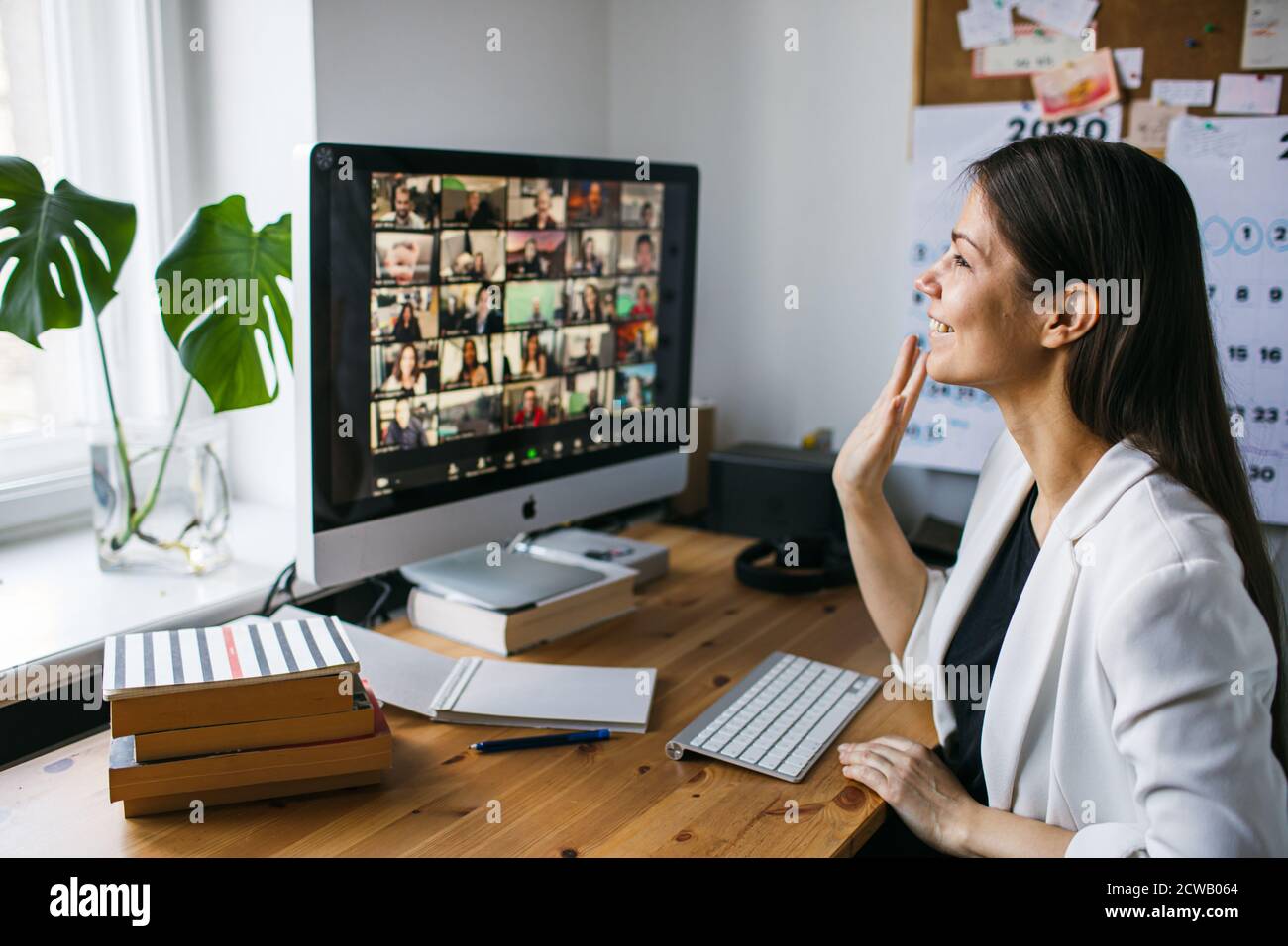 Femme souriante ayant un appel vidéo via un ordinateur dans le bureau à domicile. Vidéoconférence en ligne pour les réunions d'équipe depuis la maison. Femme d'affaires, télétravail Banque D'Images