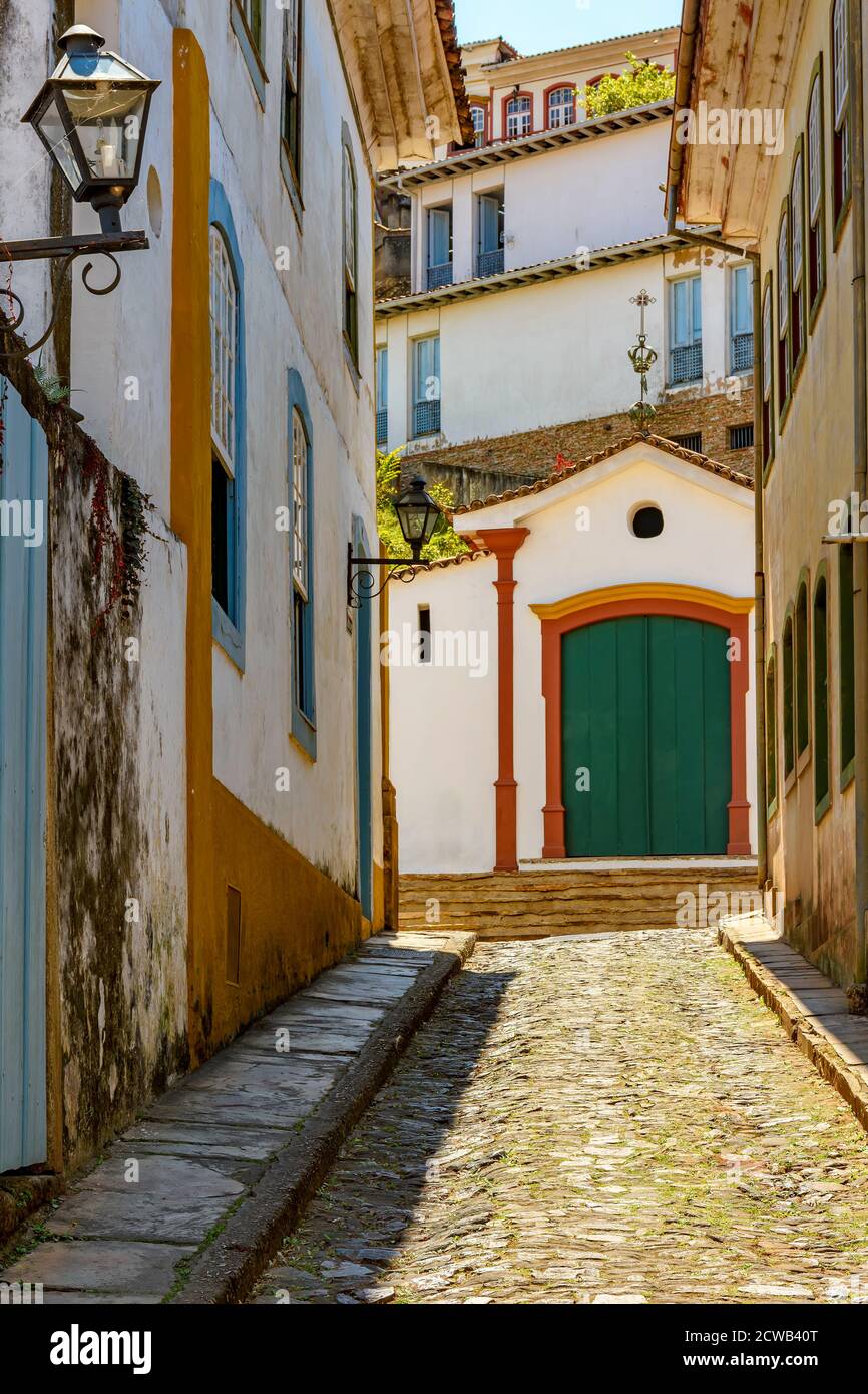 Ruelle avec de vieilles maisons et chapelle en arrière-plan dans la ville d'Ouro Preto dans l'état de Minas Gerais, Brésil Banque D'Images