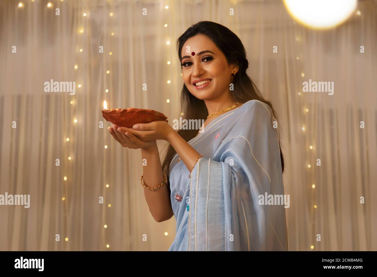Femme souriant avec une Diya dans sa main Banque D'Images