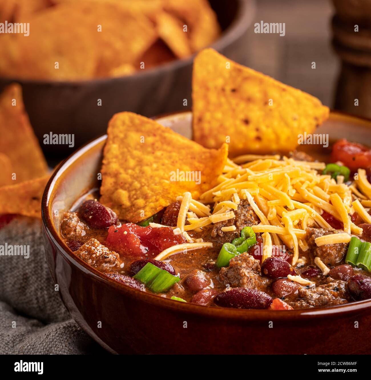 Gros plan du bol de Chili con carne avec du cheddar et jetons nacho Banque D'Images