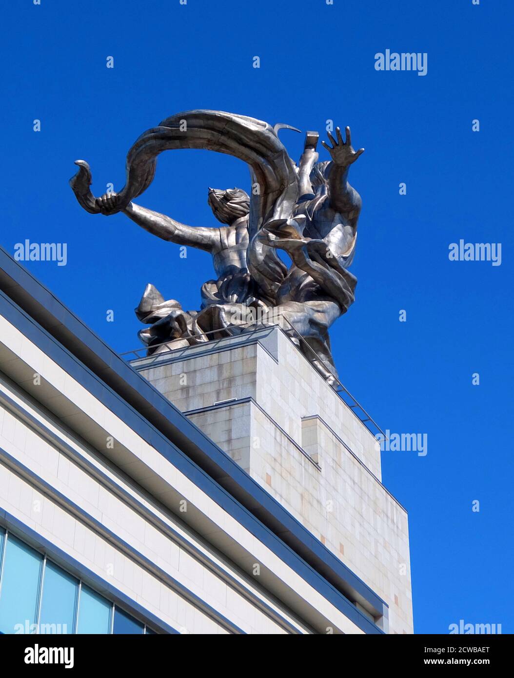 La sculpture d'une travailleuse et d'une femme kolkhoz à Moscou dépeint deux figures avec une faucille et un marteau levés sur leur tête. Il mesure 24.5 mètres (78 pieds) de haut, fabriqué en acier inoxydable par Vera Mukhina pour l'exposition universelle de 1937 à Paris et ensuite déménagé à Moscou. La sculpture est un exemple du style socialiste réaliste, ainsi que du style Art déco. Le travailleur tient un marteau en altitude et la femme kolkhoz une faucille pour former le symbole du marteau et de la faucille. Banque D'Images