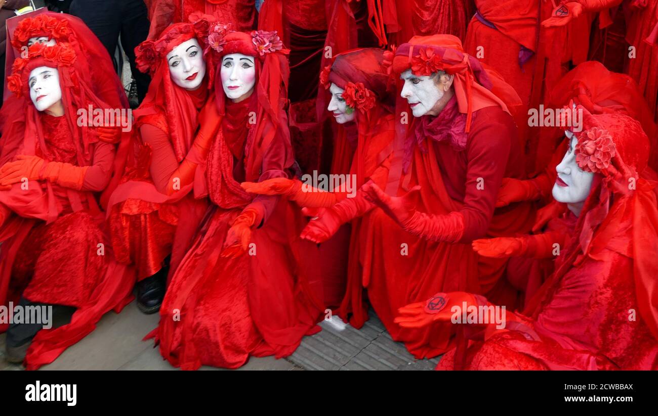 The invisible Circus at the extinction Rebellion Protest 13 octobre 2019, à Trafalgar Square, dans le centre de Londres . Le groupe invisible Circus de Bristol est composé d'artistes de rue vêtus de robes rouges symbolisant le sang qui unit l'humanité. Banque D'Images