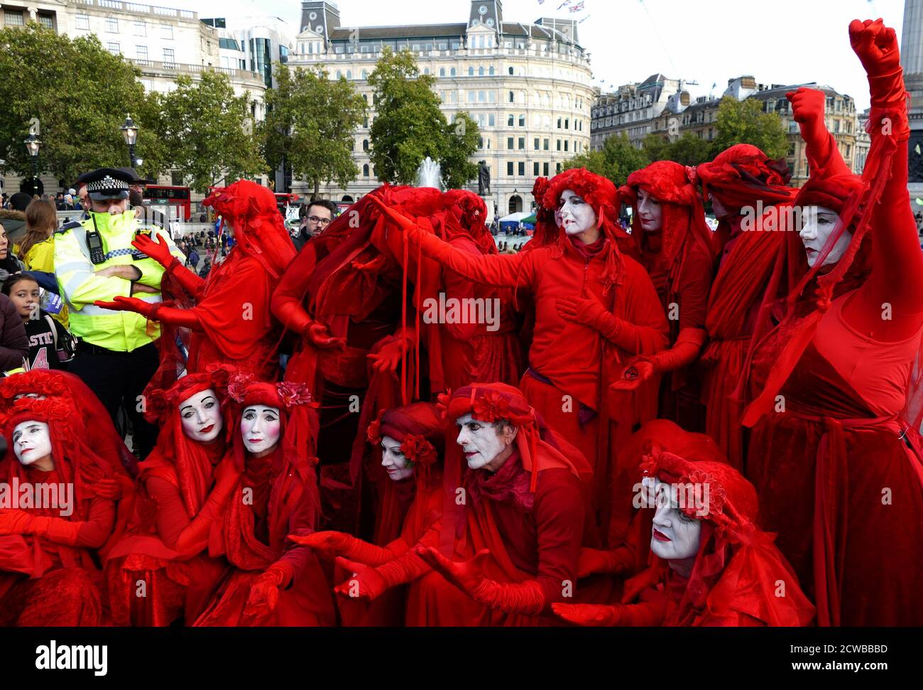 The invisible Circus at the extinction Rebellion Protest 13 octobre 2019, à Trafalgar Square, dans le centre de Londres . Le groupe invisible Circus de Bristol est composé d'artistes de rue vêtus de robes rouges symbolisant le sang qui unit l'humanité. Banque D'Images