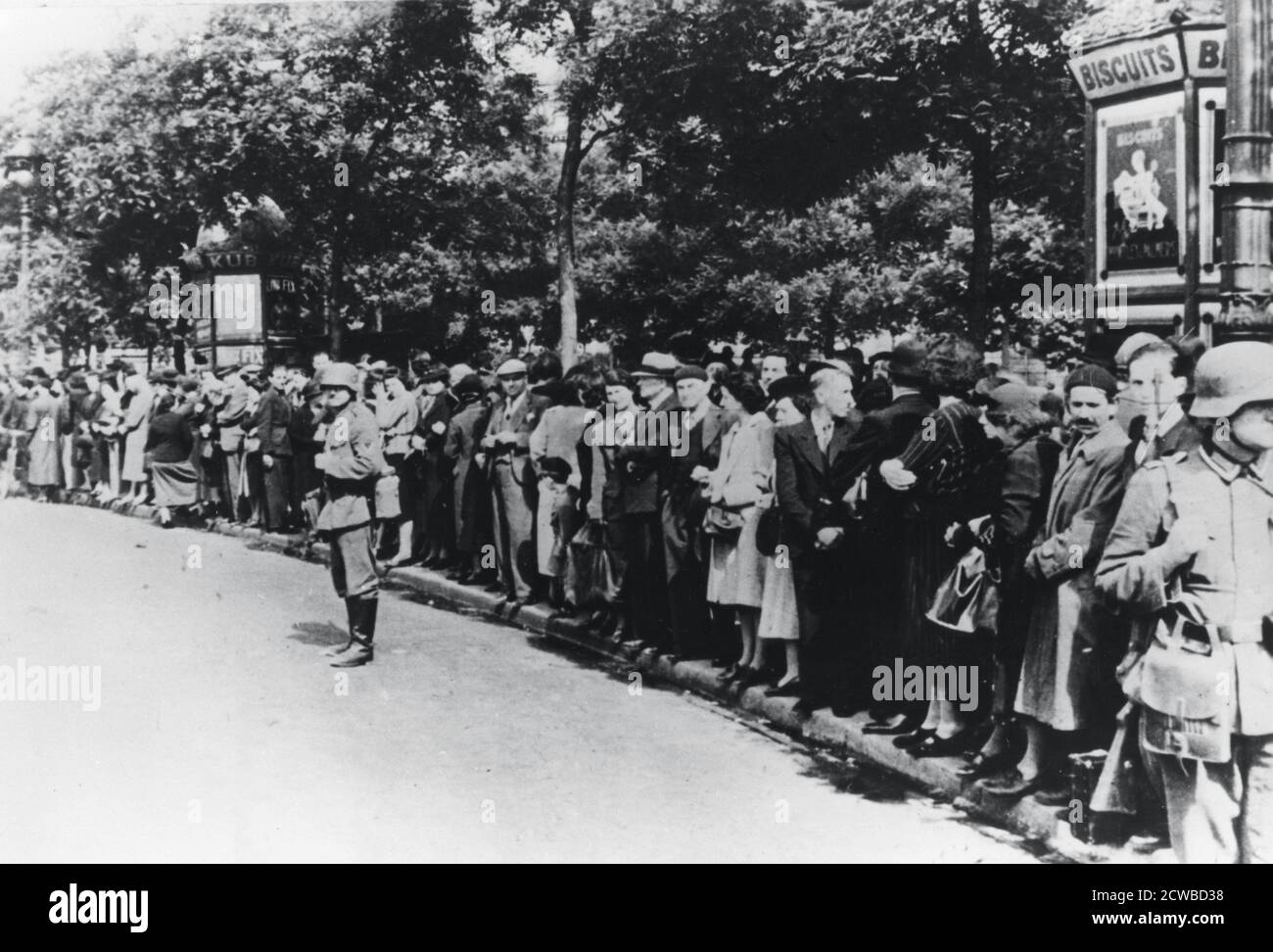Occupation allemande de Paris, 14 juin 1940. Des foules de Parisiens bordent les rues pour observer l'arrivée des troupes allemandes d'occupation. Le photographe est inconnu. Banque D'Images