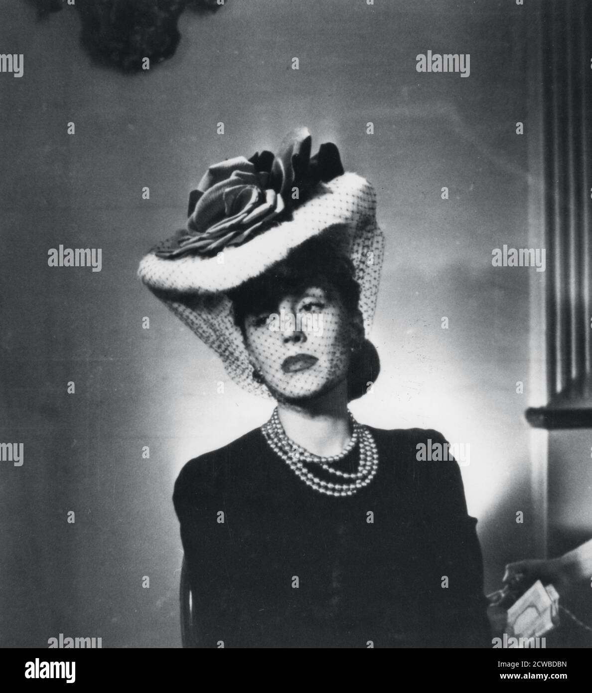 Femme portant un chapeau et un voile par le couturier français Jacques Fath, France, 1943. Le photographe est inconnu. Banque D'Images