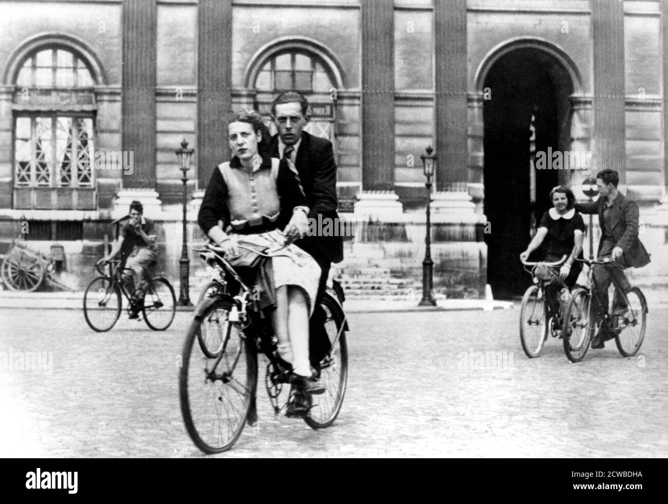 Parisiens voyageant à vélo, Paris occupé par l'Allemagne, juillet 1940. Sous l'occupation allemande, l'essence était impossible à obtenir. Seuls les véhicules de police et les véhicules transportant des denrées alimentaires ont été autorisés à voyager. La bicyclette est donc devenue le principal mode de transport pour les civils. Le photographe est inconnu. Banque D'Images