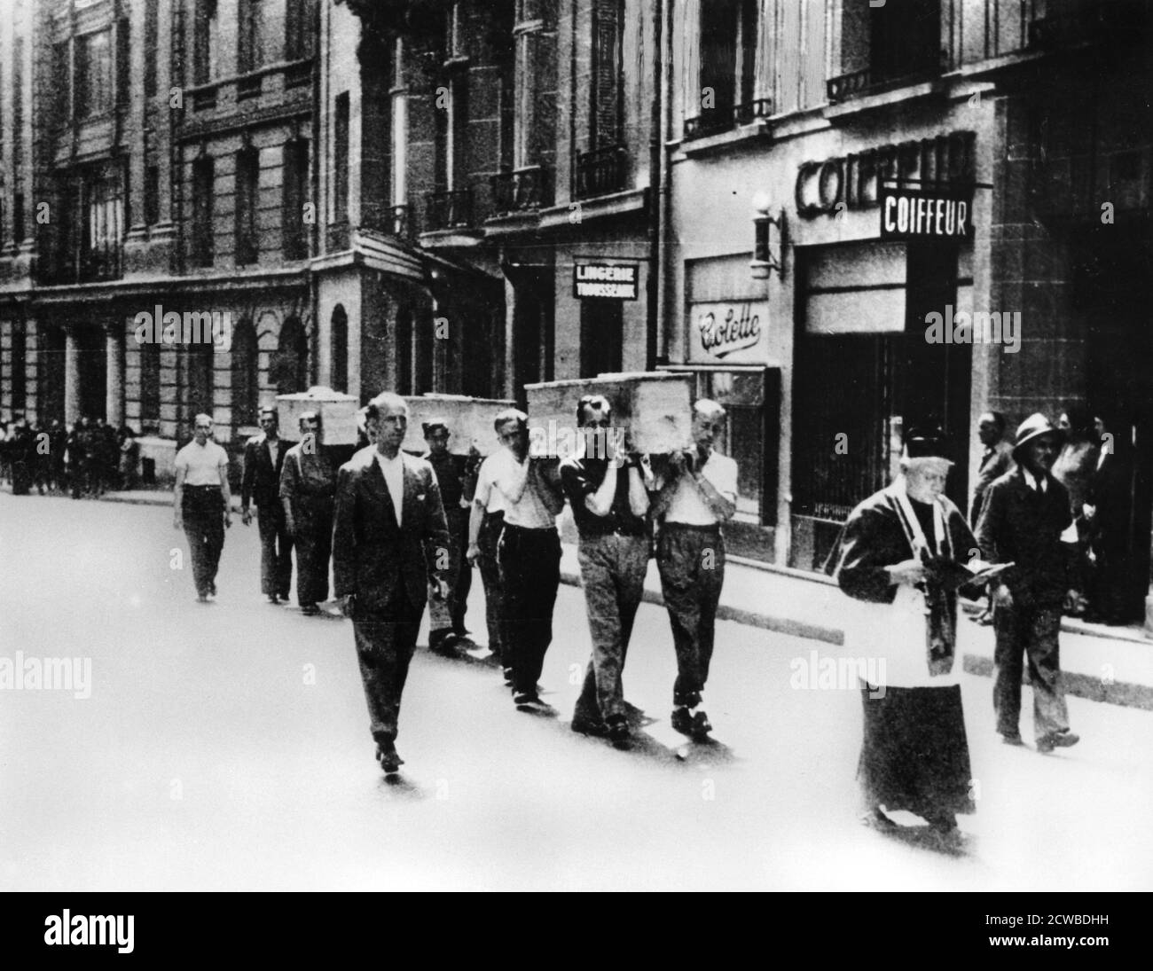 Procession funéraire des membres de la résistance française, Paris, 1944. Un prêtre marche devant des pallbearers portant les coffres des membres des Forces francaises de l'Interieur tués dans les combats pour libérer Paris. Le photographe est inconnu. Banque D'Images