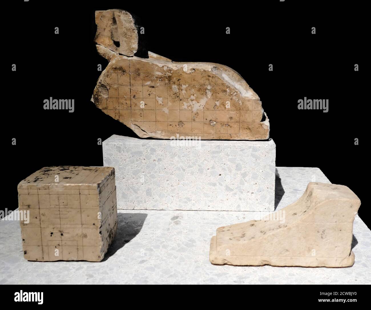 Collection d'objets égyptiens anciens comprenant le modèle d'un sphinx, pied inachevé et bloc avec système de grille Banque D'Images