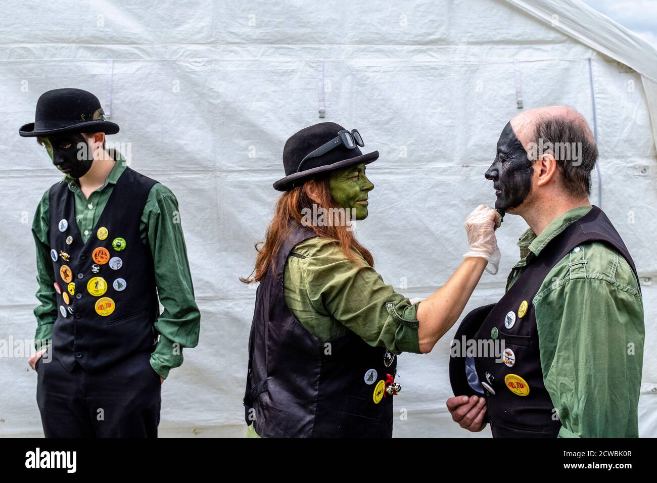 Un groupe de danseurs Morris appliquant leur maquillage avant de jouer à la Harfield Village Fete, Hartfield, East Sussex, Royaume-Uni. Banque D'Images