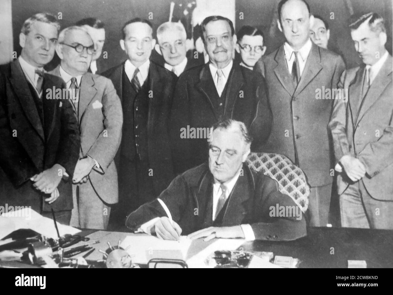 Photo en noir et blanc du président américain Franklin D. Roosevelt (1882-1945) à la Maison Blanche signant un document entouré de ses principaux collaborateurs de Brain Trust, un nom donné aux conseillers les plus proches du président. Banque D'Images