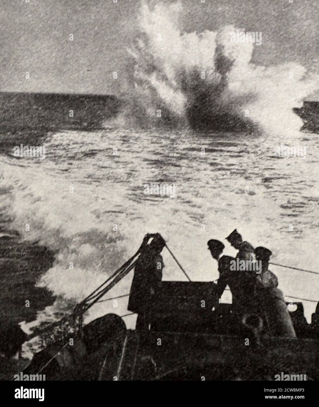 Photographie en noir et blanc de la chasse aux sous-marins allemands; un destroyer britannique détruit un sous-marin ennemi avec une charge de profondeur explosive. Banque D'Images