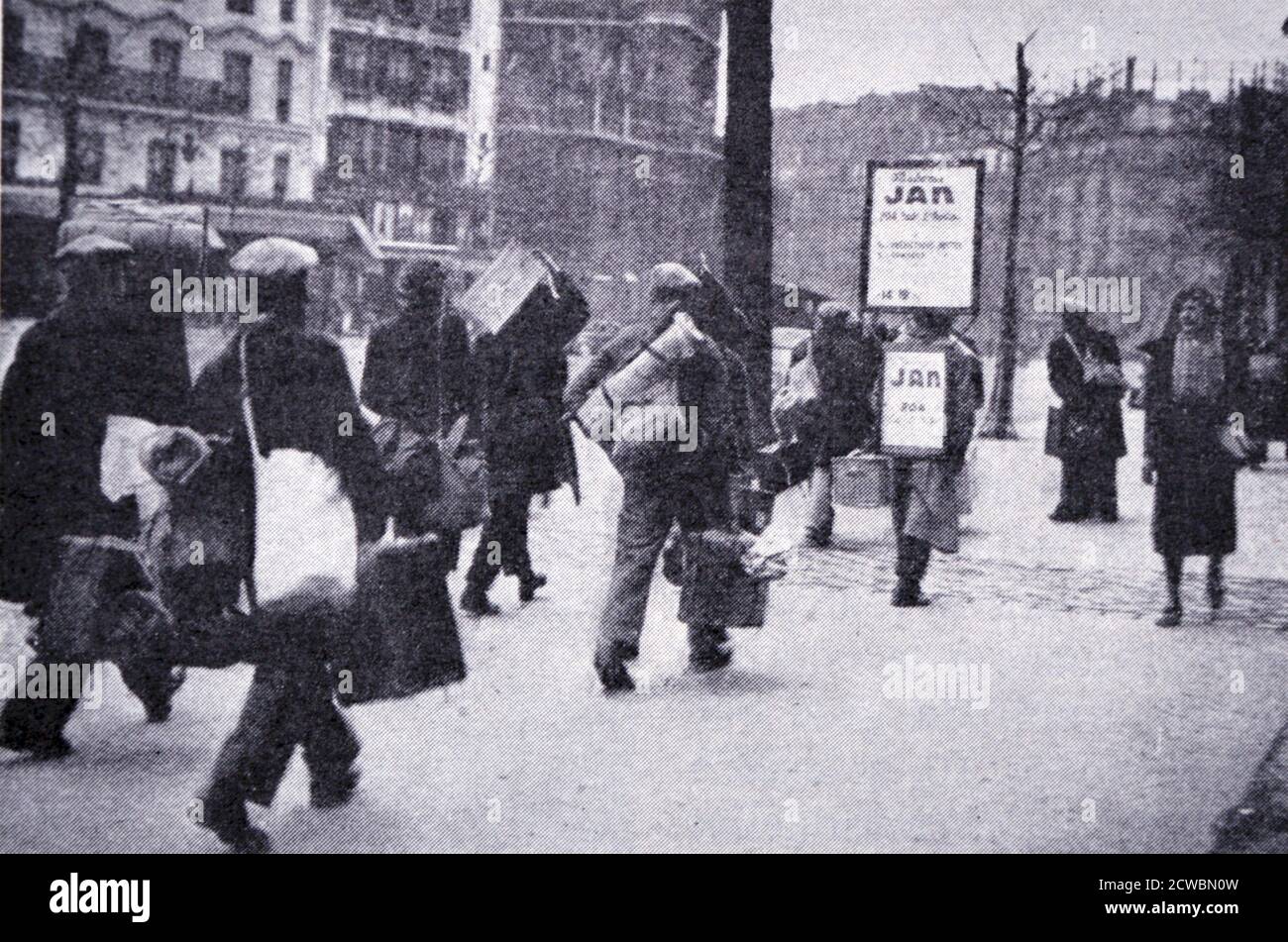 Photographie en noir et blanc de la Seconde Guerre mondiale (1939-1945); travail et secours obligatoires. Jeunes en direction de la Gare de l'est à Paris après inscription au travail. Banque D'Images