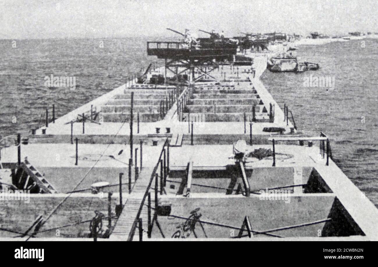 Photographie en noir et blanc de la Seconde Guerre mondiale (1939-1945) montrant l'image du port de fortune créé dans la ville normande d'Arromanches; les opérations d'atterrissage peuvent être effectuées sur des eaux calmes à l'intérieur de l'enceinte créée par des caissons et des brise-lames. Banque D'Images