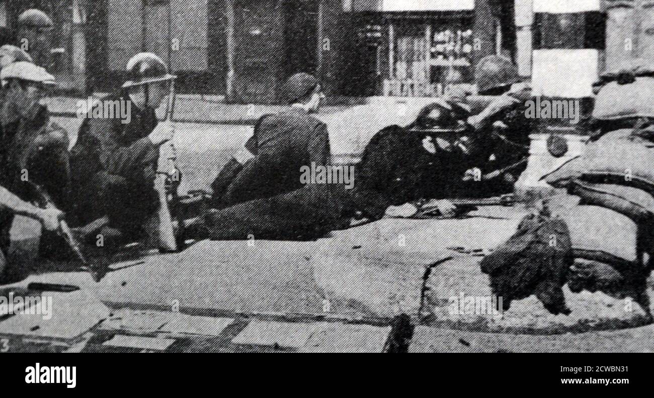 Photographie en noir et blanc de la Seconde Guerre mondiale (1939-1945) montrant des images de la libération de Paris en 1944; une unité de garde mobile repousse une attaque allemande. L'image montre des combattants derrière des sacs de sable. Banque D'Images