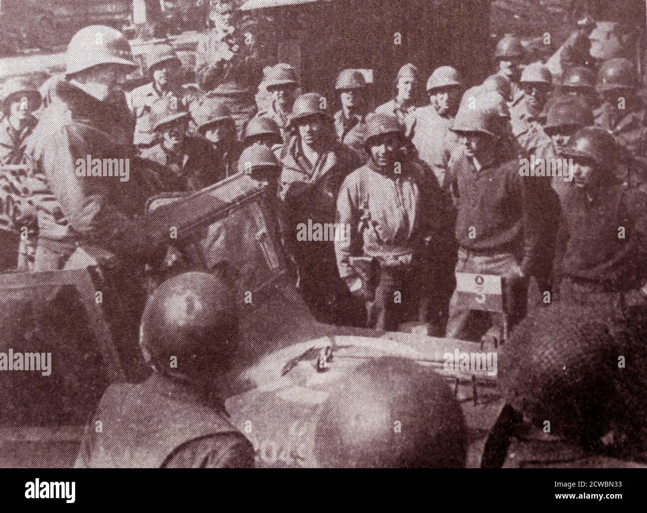 Photographie en noir et blanc de la Seconde Guerre mondiale (1939-1945) montrant l'offensive éclair menée par le général américain George S. Patton (1885-1945); Patton se tient dans une jeep s'adressant aux soldats avant la bataille d'Avranches. Banque D'Images