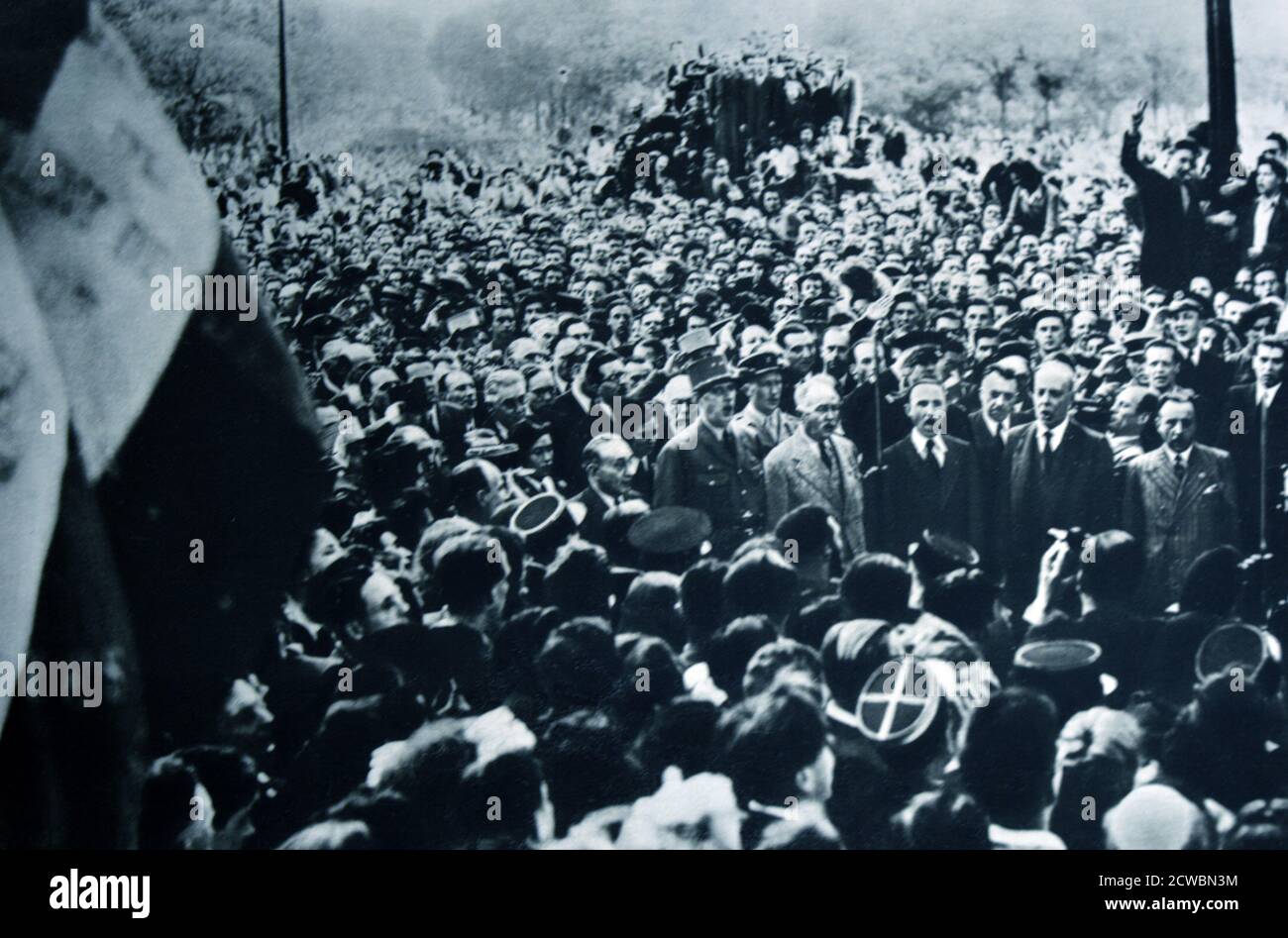 Photographie en noir et blanc de la Seconde Guerre mondiale (1939-1945) montrant des images de la libération de Paris en 1944; dans une large foule de Parisiens, le général Charles de Gaulle (1890-1970) chante la Marseillaise, hymne national français pour la première fois dans un Paris libéré. Banque D'Images