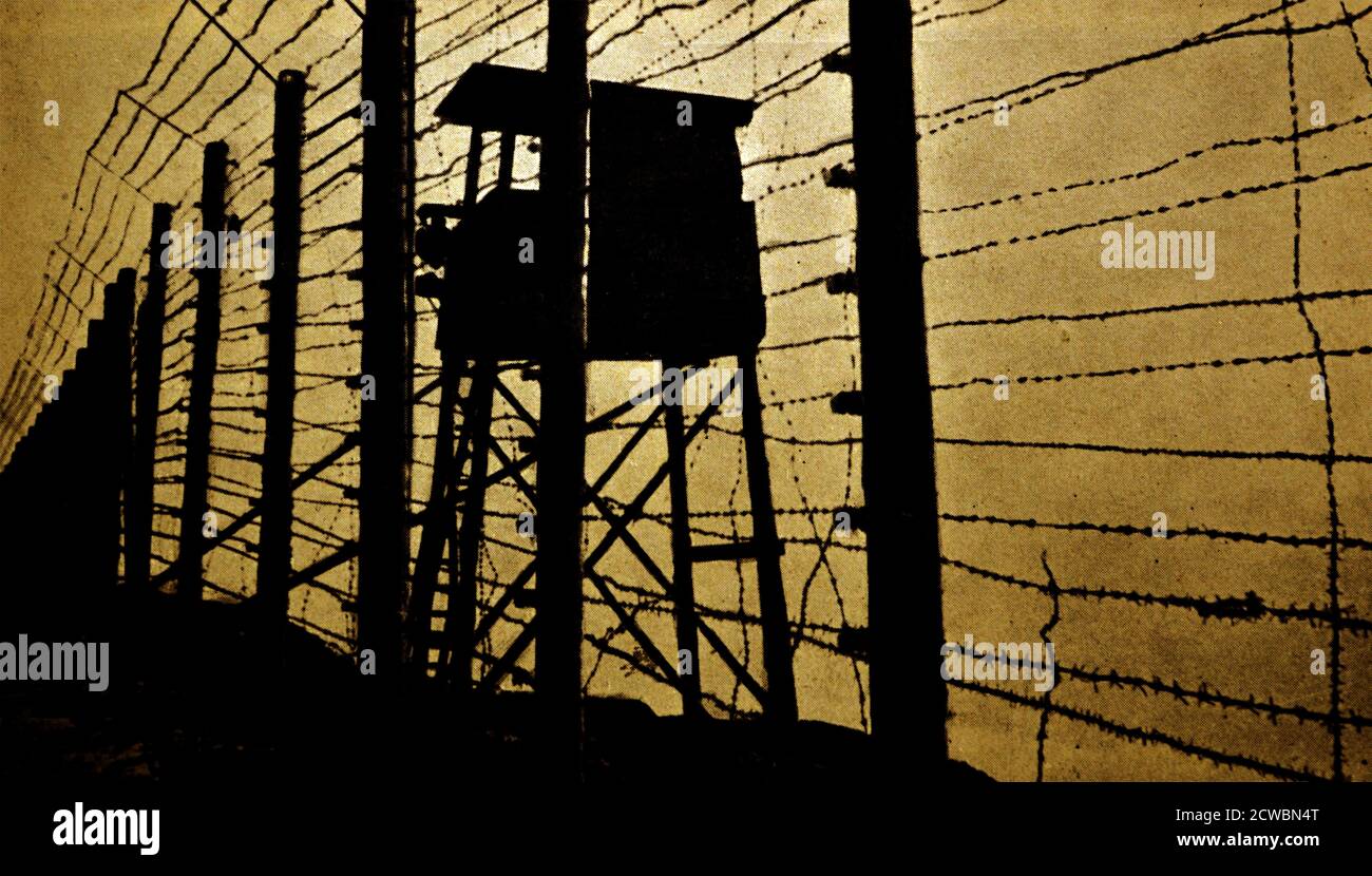 Photographie en noir et blanc de la Seconde Guerre mondiale (1939-1945) montrant une tour de garde et une clôture en barbelés au camp de concentration allemand de Struthof près du village alsacien de Natzwiller. Banque D'Images