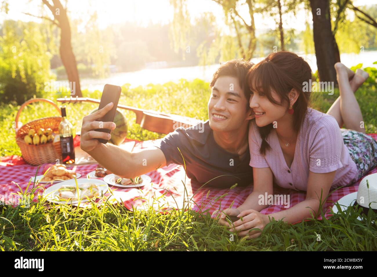 Couché sur les images de l'herbe des couples heureux Banque D'Images