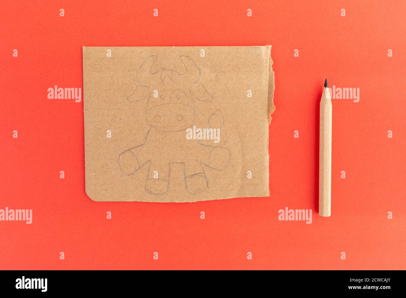 Vache artisanale en carton, Comment faire un taureau ou un boeuf à la maison. Projet d'art pour enfants. Concept DIY. Fabrication du jouet sur le rouge. Instructions détaillées sur la photo. Ste Banque D'Images