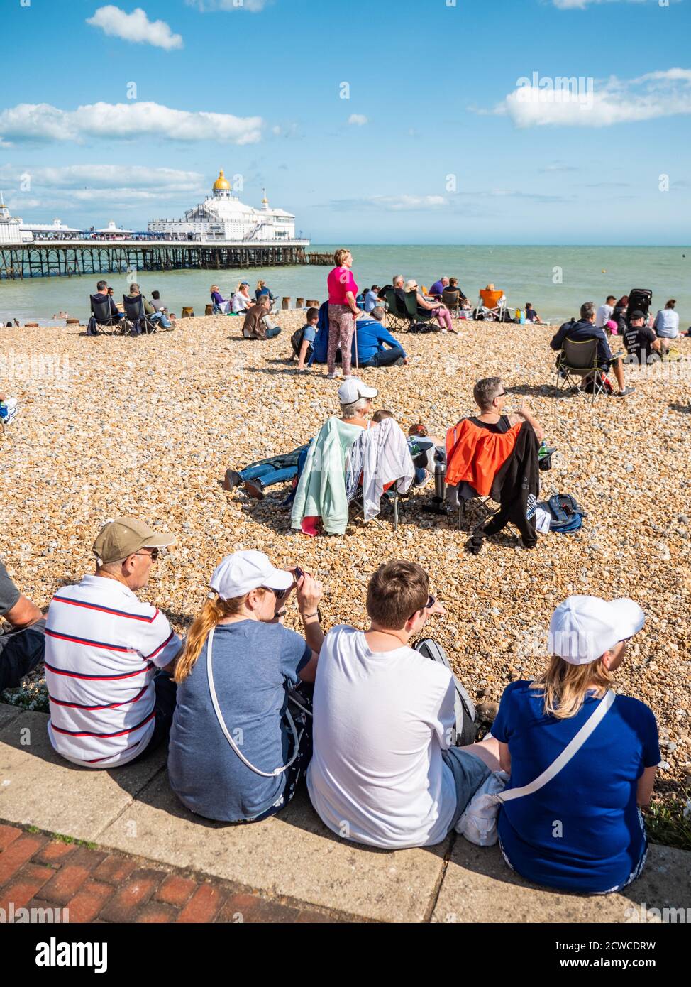 Eastbourne plage et jetée, Angleterre. Une scène estivale anglaise en bord de mer avec des touristes appréciant le temps chaud de saison sur la côte sud britannique. Banque D'Images