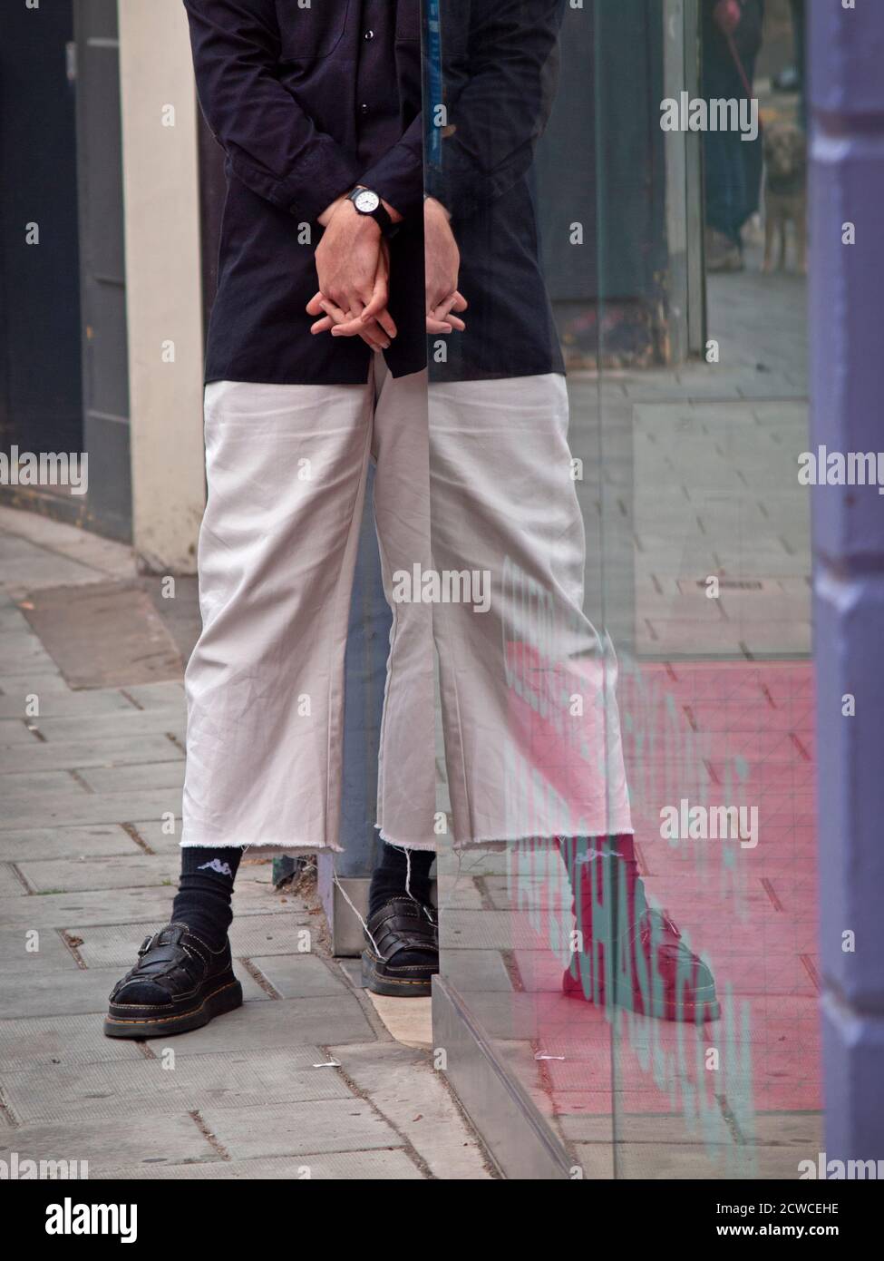 Un assistant de magasin se tient à l'entrée de sa place De travail à Brighton Banque D'Images