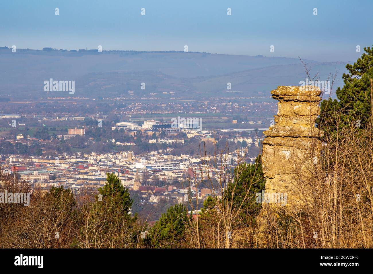 The Devil's Chimney à Leckhampton Hill avec Cheltenham Racecourse et Cleeve Hill en arrière-plan, Gloucestershire, Angleterre Banque D'Images