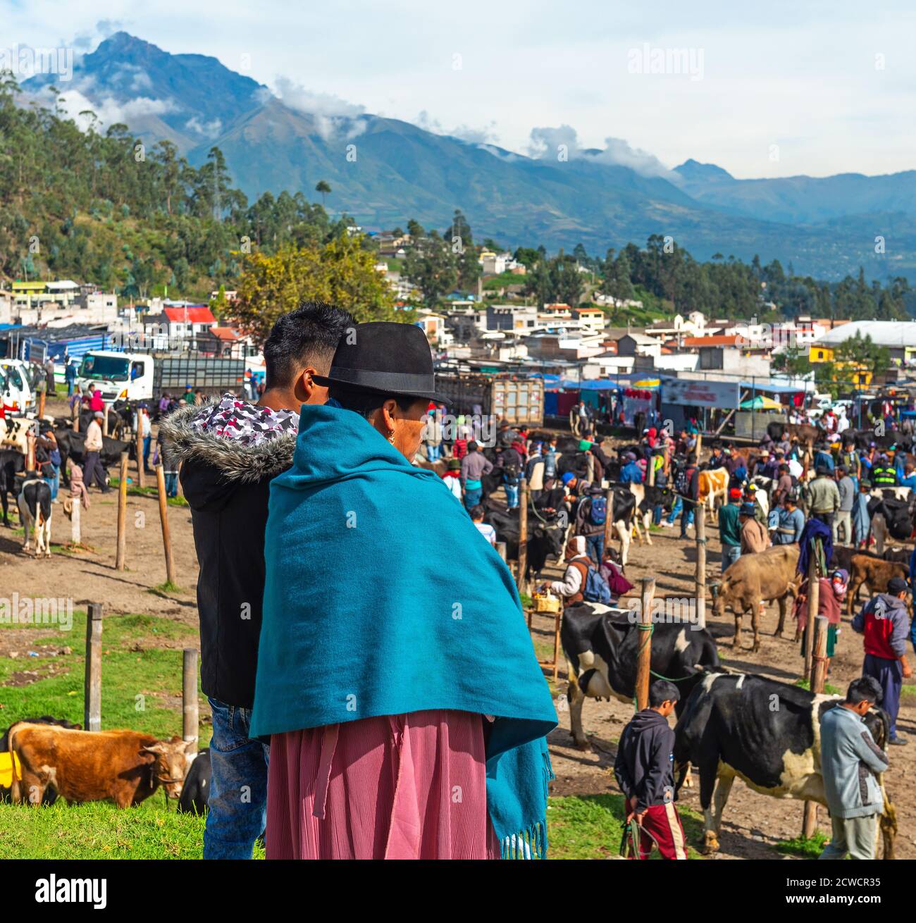 Femme indigène équatorienne Otavalo avec son fils regardant sur le marché animal d'Otavalo avec le volcan Cotacachi en arrière-plan, l'Equateur. Banque D'Images