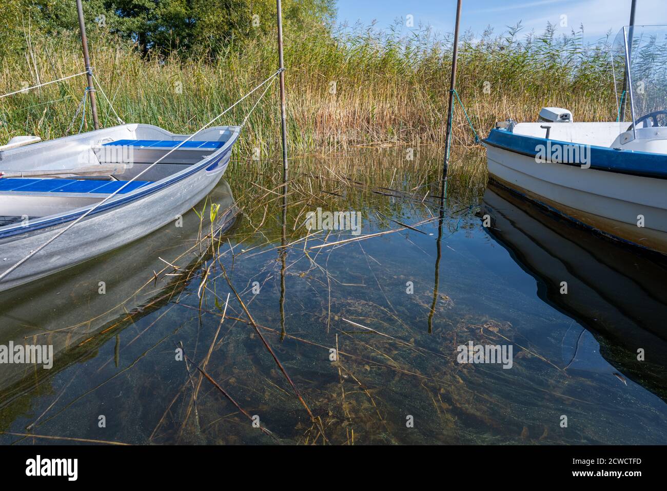 Réflexion dans l'eau verte entre deux petits bateaux dans un lac. Photo de Ringsjon, comté de Scania, Suède Banque D'Images
