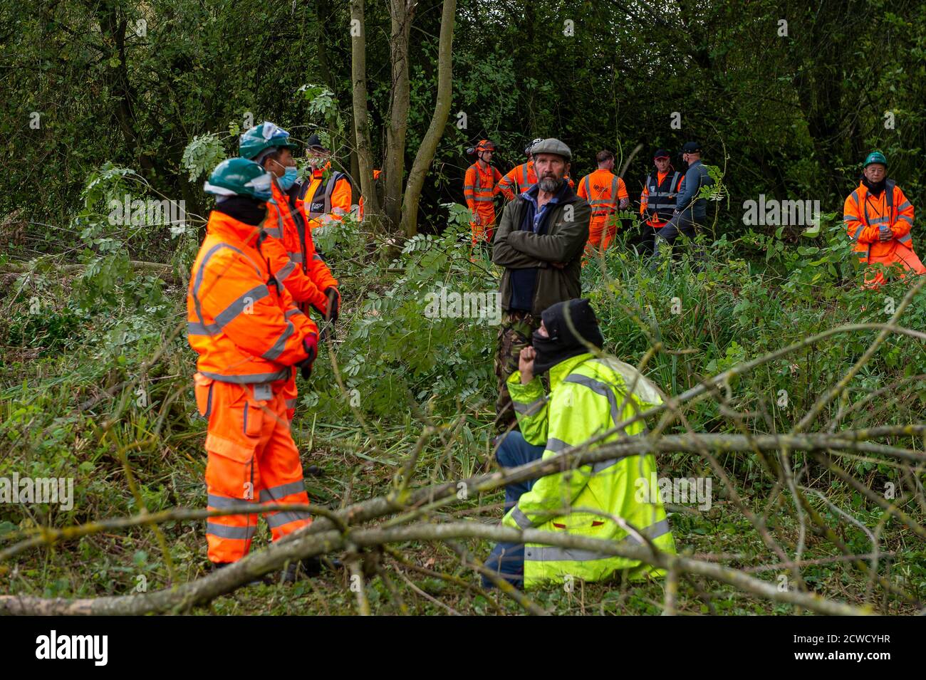 Denham, Royaume-Uni. 29 septembre 2020. Les gardes de sécurité HS2 entourent deux protecteurs d'arbre lorsqu'ils regardent les coupe-arbres abattre des arbres pour HS2 aujourd'hui dans le parc national de Denham, dans une zone où les protecteurs d'arbres HS2 Rebellion sont publics et à l'extérieur de la zone dans laquelle HS2 est autorisé à travailler. Environ 28 agents NET Enforcement et agents de sécurité HS2 ont empêché les protecteurs d'arbre de regarder l'évolution de la destruction des arbres. Les travaux de construction du HS2 mettent en péril 693 sites fauniques, 108 anciennes terres boisées et 33 ISSS. Crédit : Maureen McLean/Alay Live News Banque D'Images